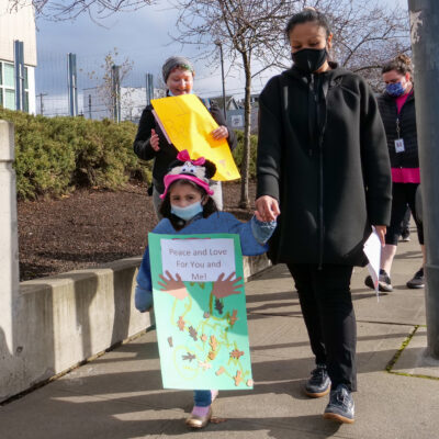 Children and teachers march outside Wellspring's building